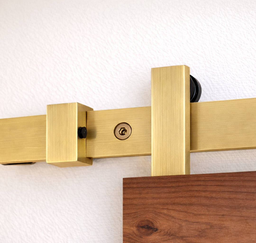 Matte gold sliding door hardware Runway installed on rustic wooden doors with top mounted trolleys